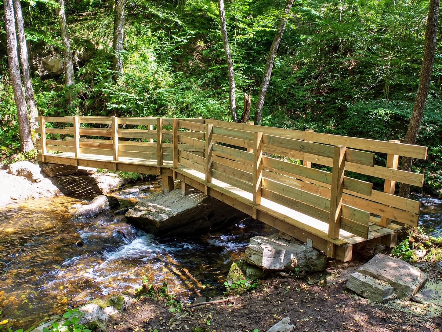 Pose d’une passerelle en bois au-dessus d’un ruisseau